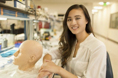 Portrait of Holly Sit in Lab with a human head model