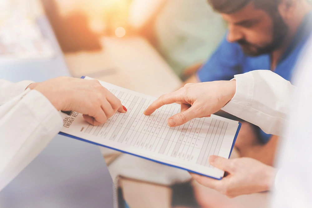 physicians pointing to informational papers on a clip board