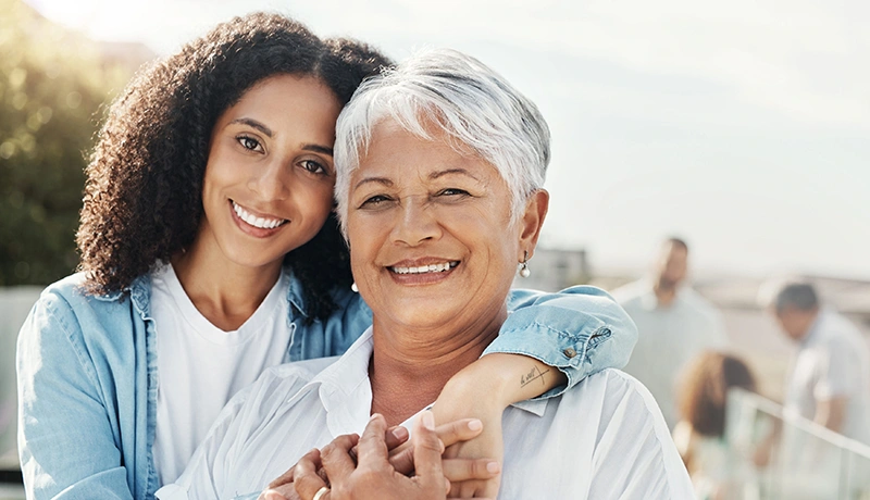 a mother and daughter embracing and smiling