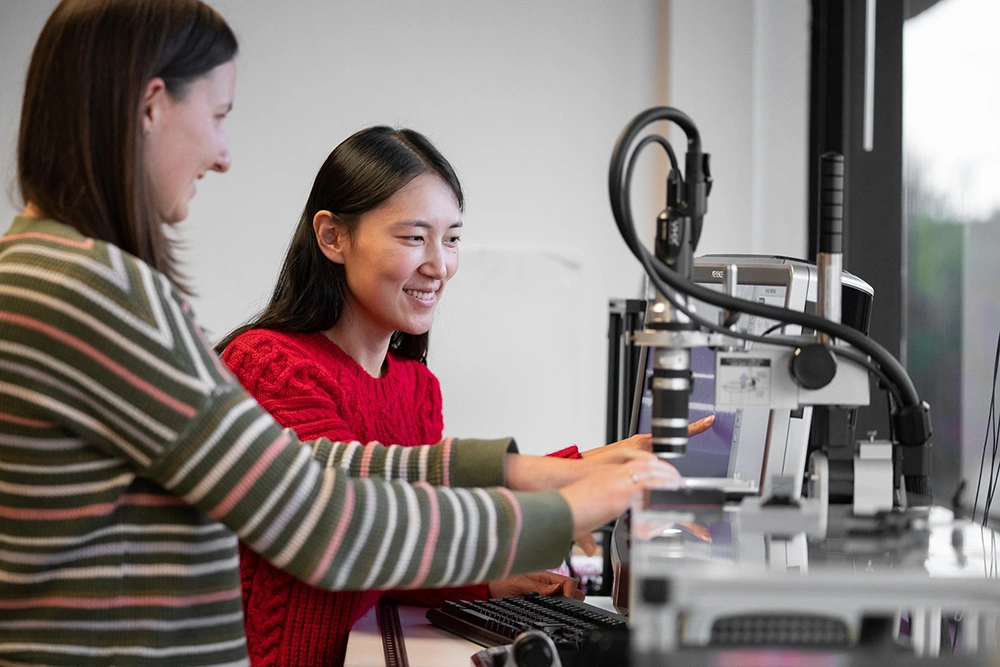 2 women in engineering working with machines and computers