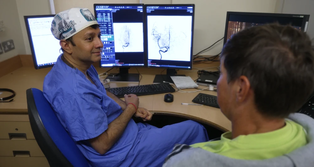 Patient with a doctor looking at angio on computer