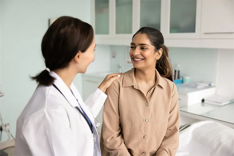 A woman and a doctor smiling.